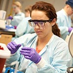 Female working with chemicals in a chemistry lab.